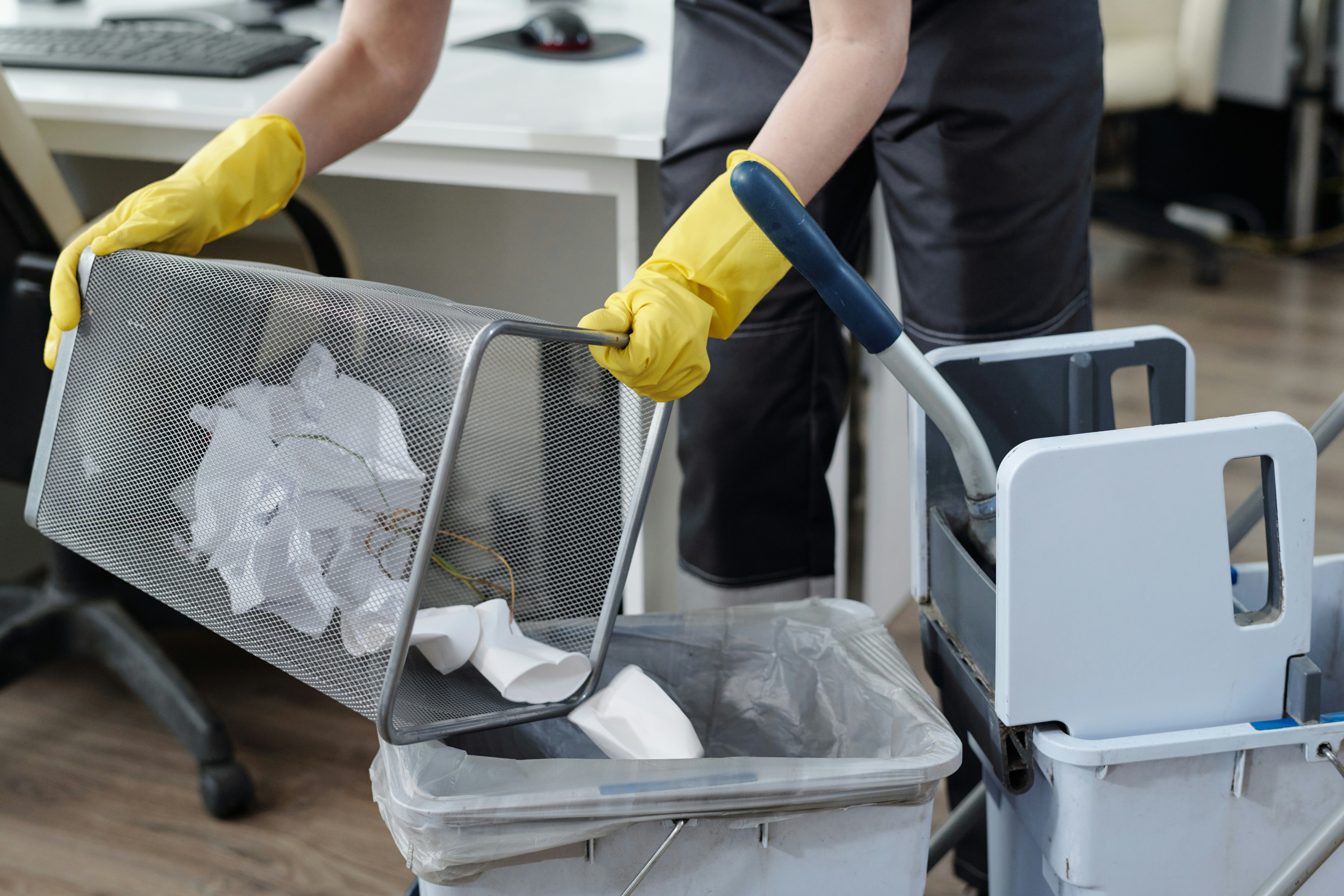 Janitor emptying a trash basket